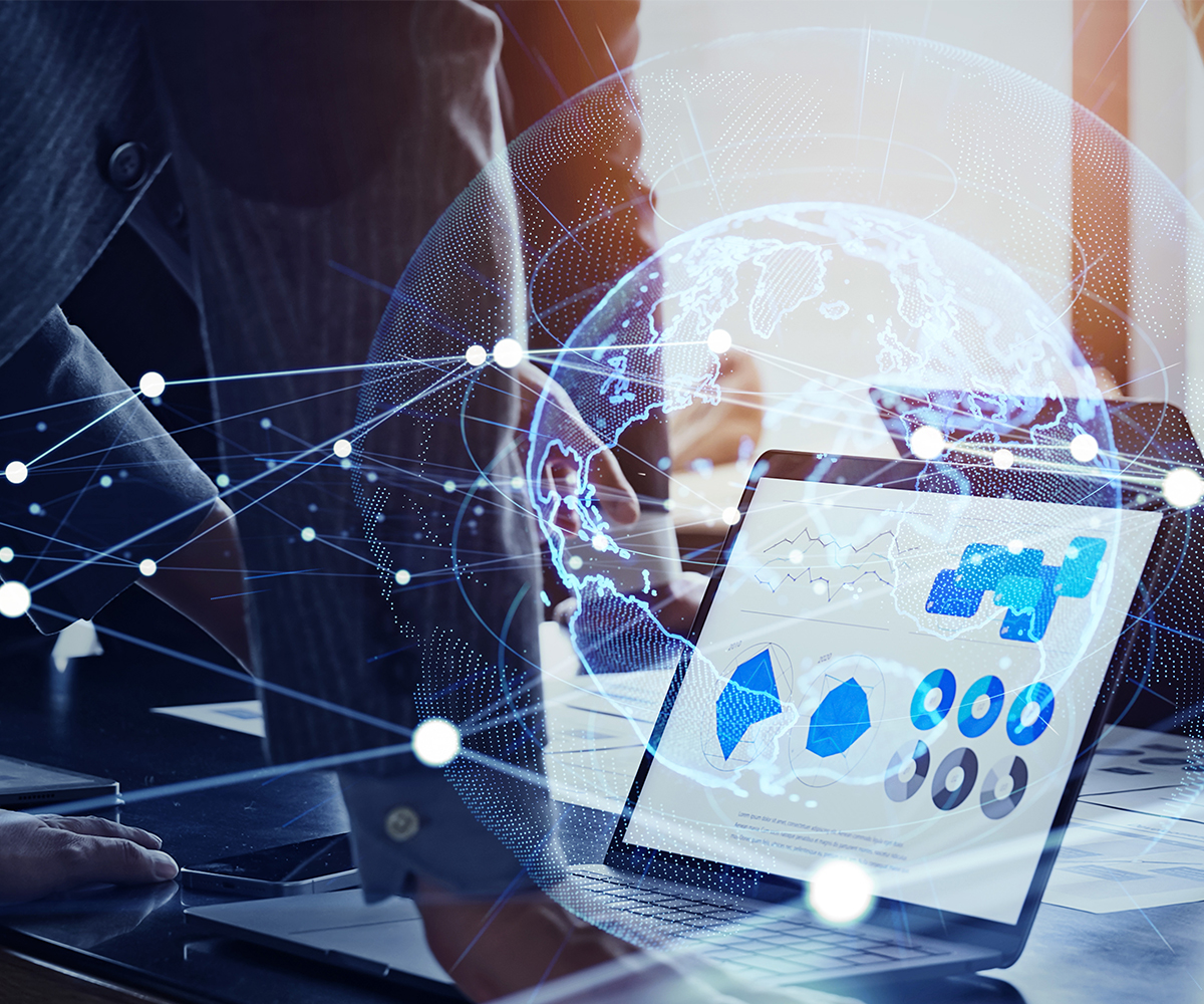Computer portatile appoggiato su un tavolo con grafici sullo schermo e in overlay connessioni grafiche tra il mondo e la rete internet